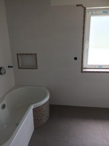 Badewanne und Wand in hellen Fliesen Oberderdingen