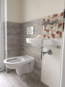 WC und Waschbecken mit Mosaikverfliesung