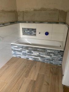 Badewanne in Anthrazit-Fliesen und Holzboden-Optik