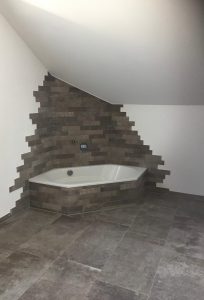 Anthrazit-Fliesen in modernem Bad mit Eckbadewanne